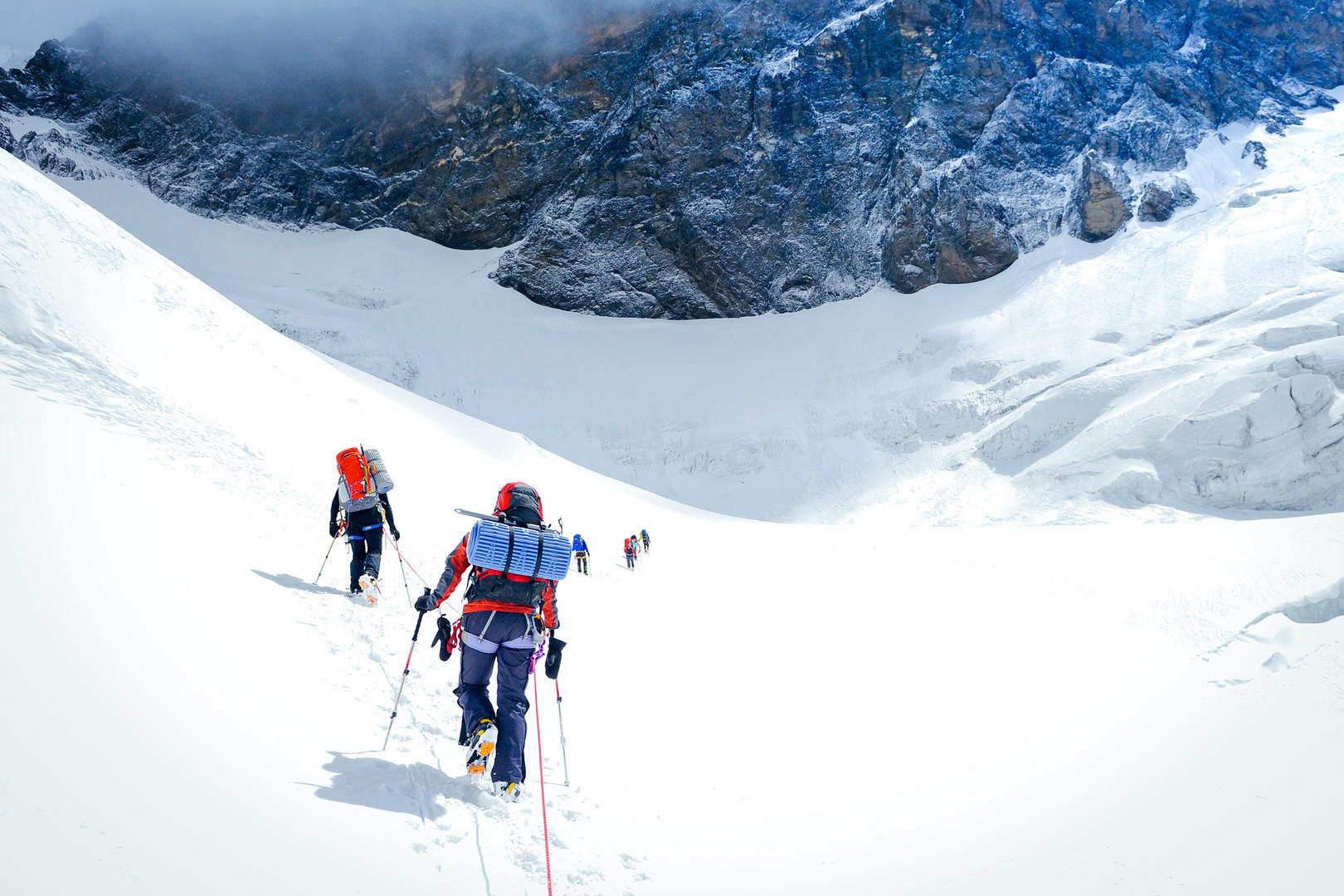 Climbers reaching a high summit together — the logical progression from Swan Slab to bigger objectives, measured in years of craft not weeks of enthusiasm