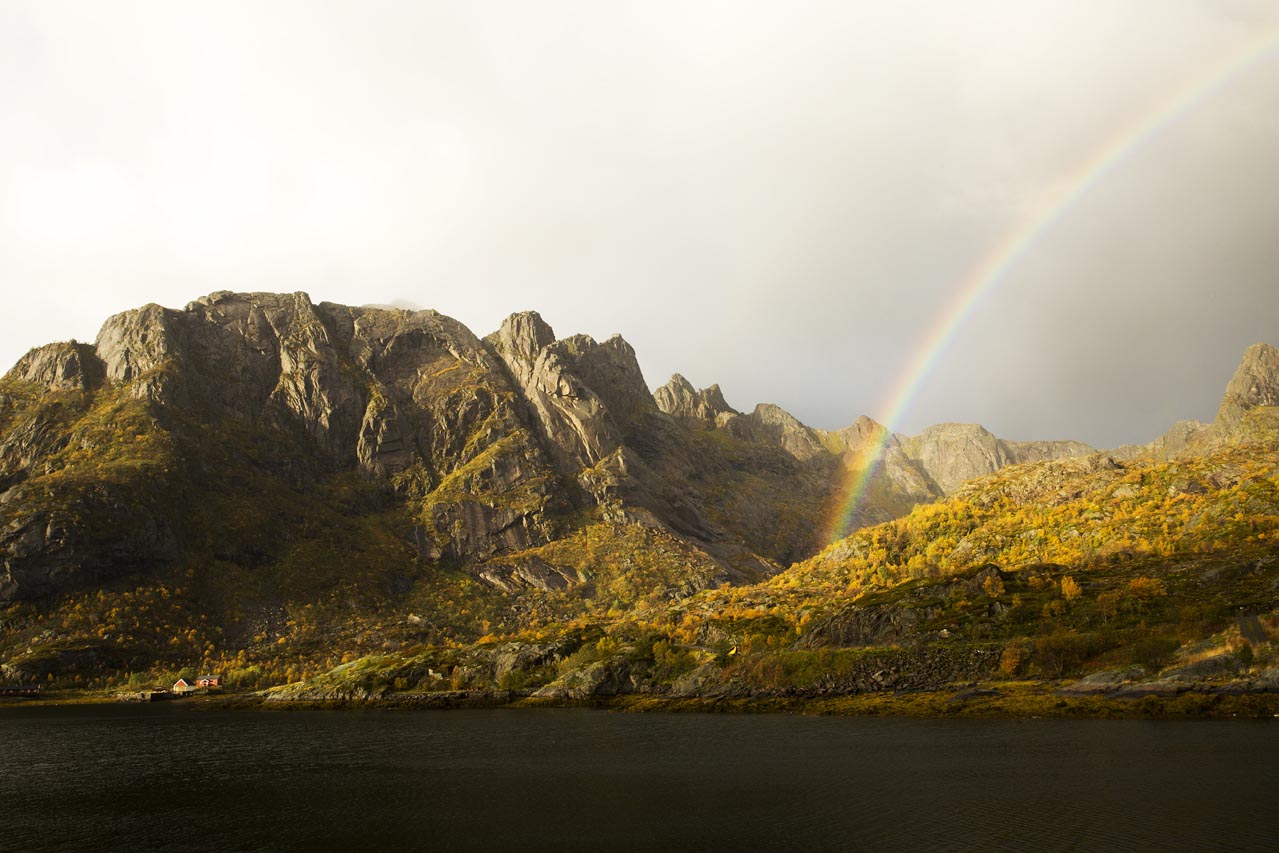 Rainbow over the Lofoten coastline after a session at Unstad — the reward for staying out in the squall