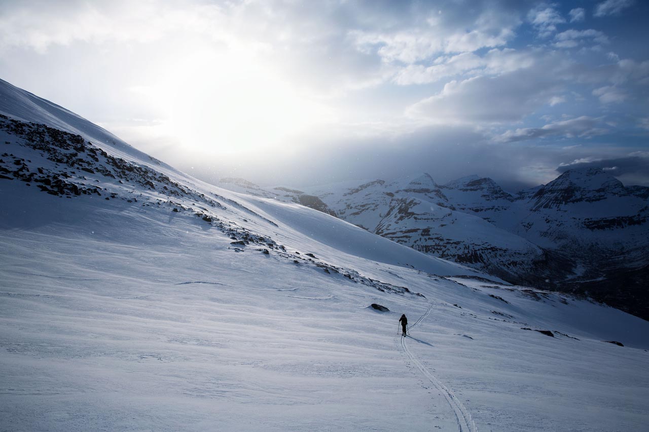 Two ski tourers crossing a high ridge — at altitude the margin between moving and not moving is everything